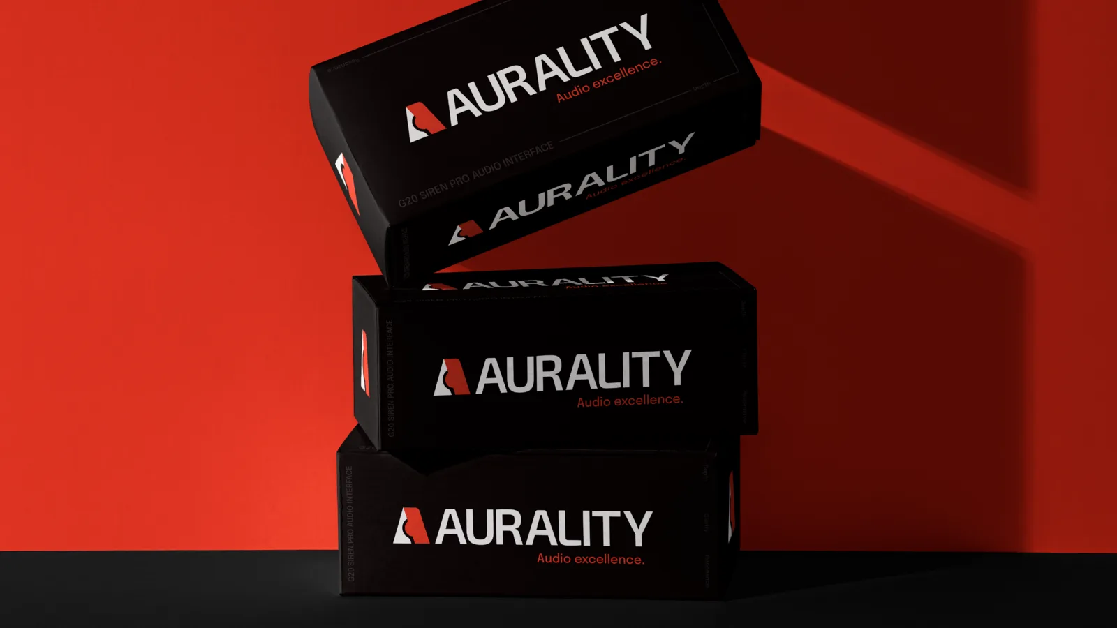 Three stacked black Aurality boxes floating over a deep red ground